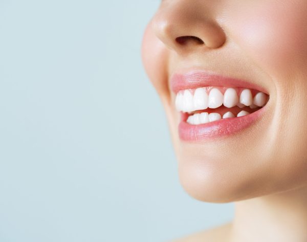Perfect healthy teeth smile of a young woman. Teeth whitening. Dental clinic patient. Image symbolizes oral care dentistry, stomatology.